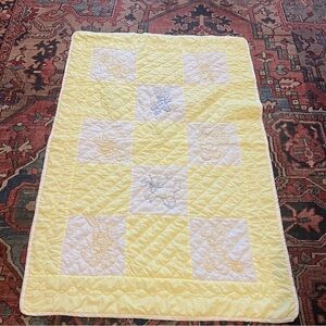 Vintage yellow and white baby quilt with hand stitched animals